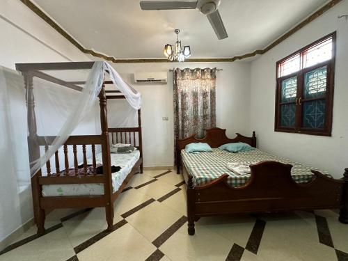 a bedroom with two beds and a bunk bed at Pazuri apartment in Ngambo