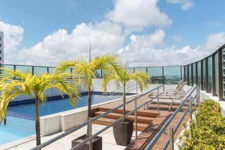 a balcony with palm trees and a swimming pool at Beach Class Santa Maria by Easy Home in Recife