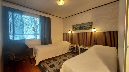 Una habitación de hotel con dos camas y una ventana. en ANNA Jeppo Guesthouses, en Uusikaarlepyy