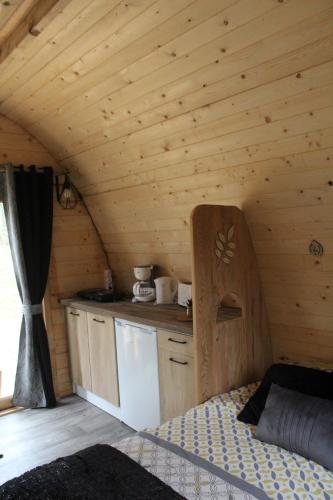 a kitchen in a log cabin with a bed in it at CABANE INSOLITE et COCOONING-2personnes-CAMPING LE BEL AIR-LE FRESNE in Limogne-en-Quercy