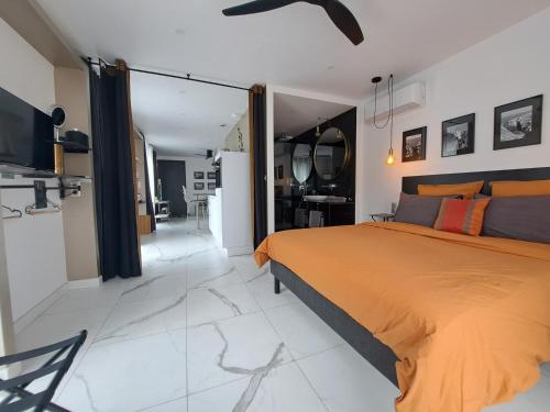 a bedroom with a orange bed and a living room at Le 7 in Vieille-Toulouse