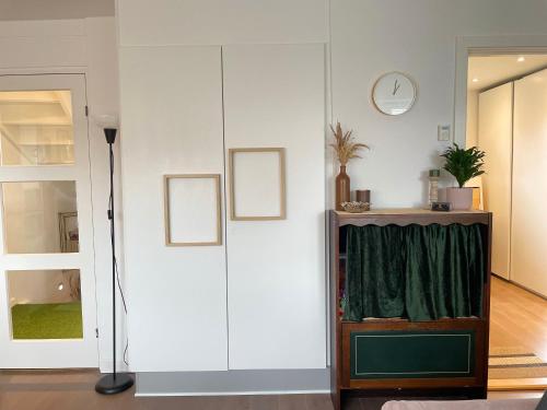Your Perfect Aarhus Staycation في أُرهوس: غرفة مع خزانة بيضاء كبيرة مع ستائر خضراء
