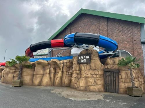 a water slide in front of a building at Lyons Robin Hood, RHYL "The Beach Hut" in Rhyl