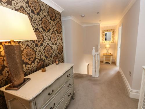 um quarto com uma cómoda com um candeeiro em Moor View em Glossop