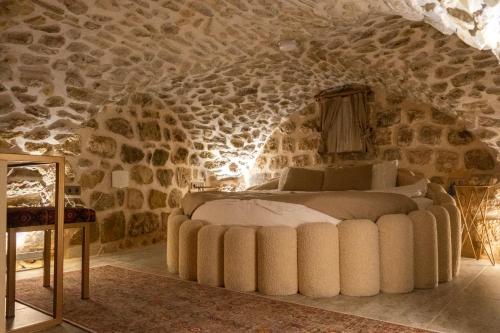 a bedroom with a bed in a stone wall at Ana Talia House in Mardin