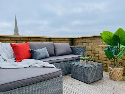 a patio with a couch and a table at Stunning Terrace Apartment - City Centre & Next to Tube Station in Ealing