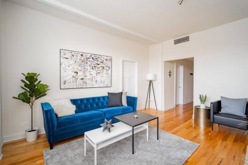 a living room with a blue couch and a table at Lively 3BR Apt in Chicago - Milwaukee N3 in Chicago