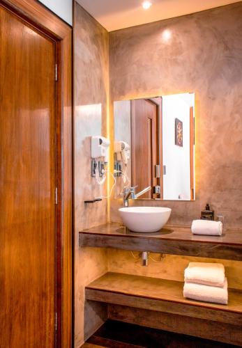 a bathroom with a sink and a mirror at Madero Hotel & Suites in La Paz