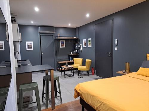 a bedroom with a bed and a desk and chairs at Le 7 in Vieille-Toulouse