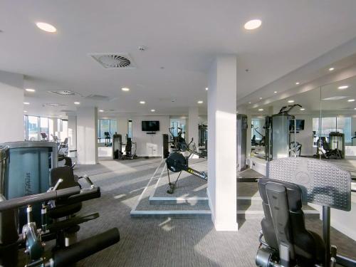 a gym with treadmills and ellipticals in a building at Snuggle Inn - Riverside Apartments - Views Over looking London River Thames, Close to O2 Arena, London Excel, London City Airport, Thames Clipper- River Boat Service, Woolwich Ferry, Onsite parking, TWIN ROOM OPTION available in London