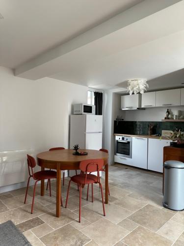 eine Küche mit einem Holztisch und Stühlen im Zimmer in der Unterkunft La cour fleurie in Neuville-aux-Bois