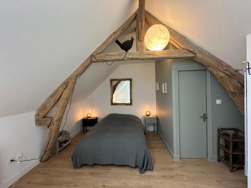 - une chambre mansardée avec un grand lit dans l'établissement La cour fleurie, à Neuville-aux-Bois