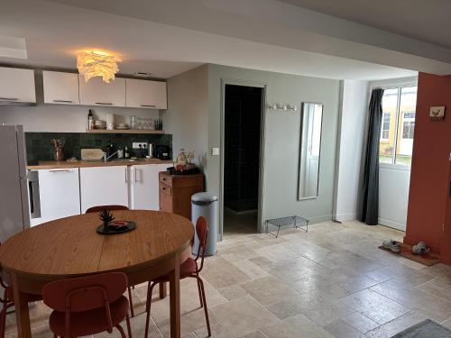eine Küche mit einem Holztisch und einem Esszimmer in der Unterkunft La cour fleurie in Neuville-aux-Bois