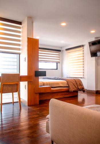 a bedroom with a bed and a table and a chair at Madero Hotel & Suites in La Paz