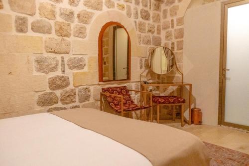 a bedroom with a bed and a mirror and a chair at Ana Talia House in Mardin