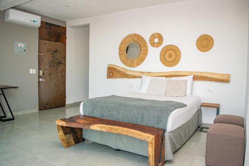 a bedroom with a bed with a wooden bench next to it at Tres Piedras 