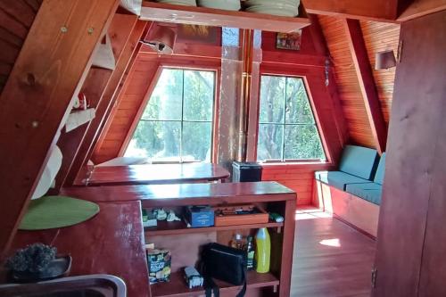 a tiny house with a desk and a window at A-frame off the grid in Khalikerí