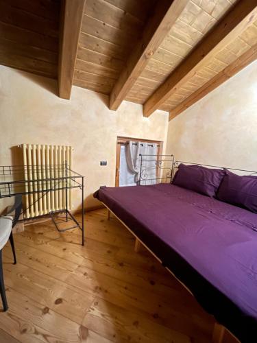 a bedroom with a purple bed and a wooden floor at Miramountains in La Thuile