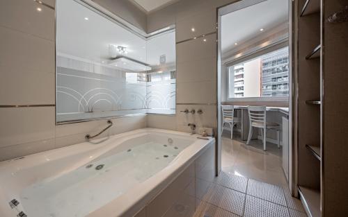 a large white bathroom with a tub and a window at Hotel Nuevo Ostende by bund in Mar del Plata