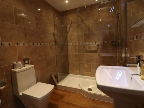 a bathroom with a toilet and a sink and a shower at Green Grove Country House in Malham