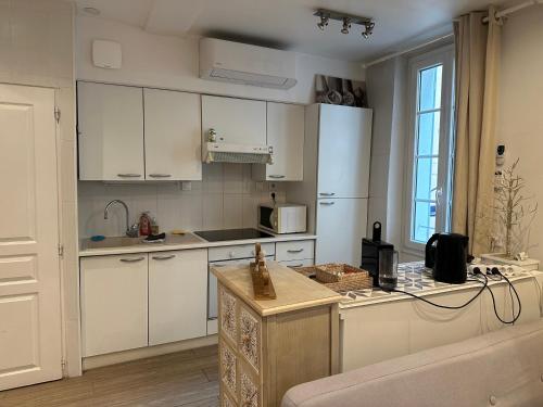 une cuisine avec des armoires blanches et un comptoir dans l'établissement Studio tt équipé parking cœur ville, à Sanary-sur-Mer