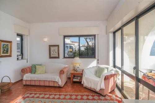 een woonkamer met 2 stoelen en een bank bij Casa da Praia in Luz