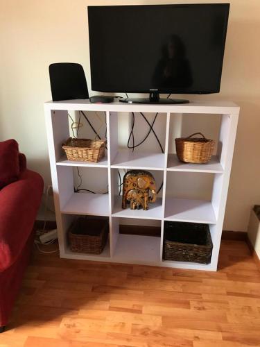a white shelf with a tv on top of it at The South Sunny House - A Casa a Sul in Olhão