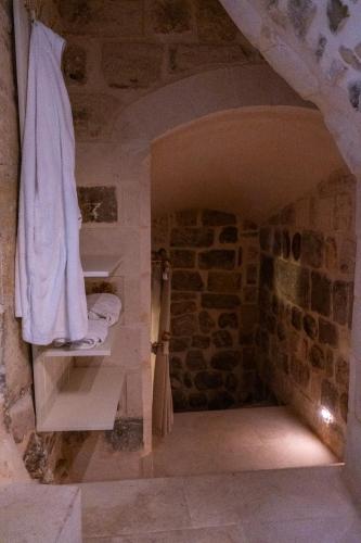 a bathroom with a stone wall with a towel on a shelf at Ana Talia House in Mardin