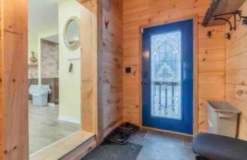 Habitación con puerta azul en una pared de madera. en Riverfront Suites, Quinte, ON, en Frankford