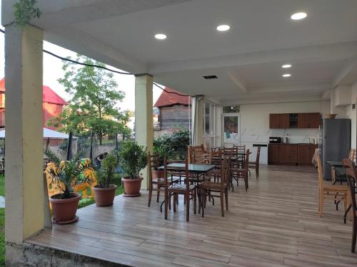 an outdoor patio with tables and chairs and a kitchen at Tornado Hotel in Ureki