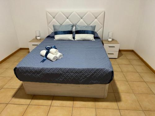 a bed with a blue comforter and a stuffed animal on it at Alforra Residence-T2 completo no Centro in Câmara de Lobos