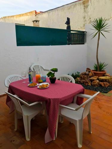 a table with a red table cloth on a patio at The South Sunny House - A Casa a Sul in Olhão