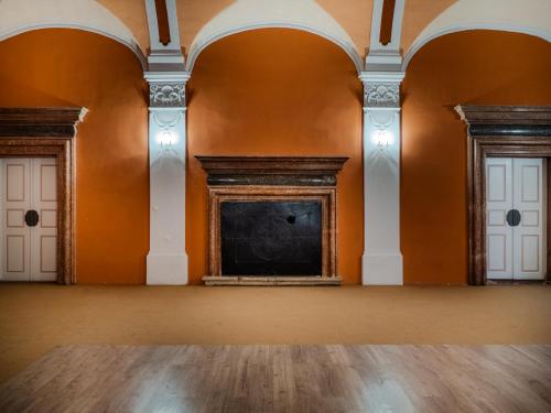 an empty room with orange walls and white doors at Zamek Międzylesie in Międzylesie