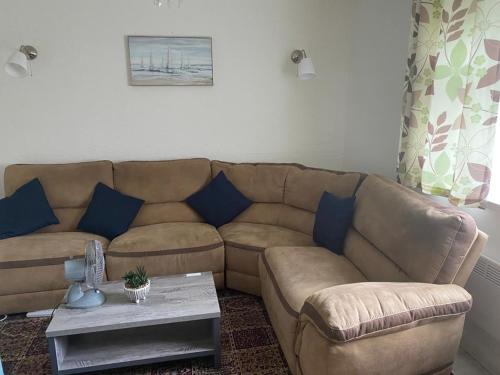 ein Wohnzimmer mit einem braunen Sofa und blauen Kissen in der Unterkunft Cozy flat in Birmingham with Parking in Birmingham