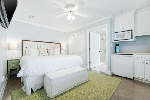 a bedroom with a white bed with a ceiling fan at Dock n Dune in Seagrove Beach