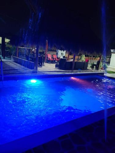 - une piscine avec des lumières bleues la nuit dans l'établissement CASA FINCA TURBACO VIA CAÑAVERAL, à Turbaco