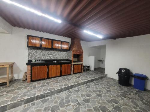 a kitchen with wooden cabinets and a brick wall at CASA FINCA TURBACO VIA CAÑAVERAL in Turbaco