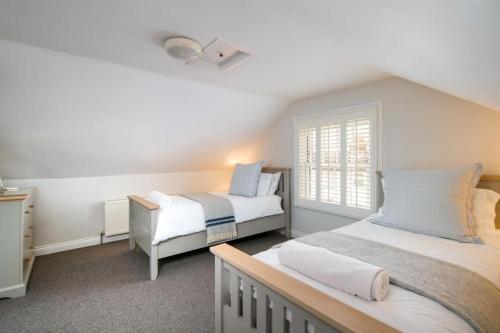 考斯的住宿－Crossjack Cottage，一间卧室设有两张床和窗户。