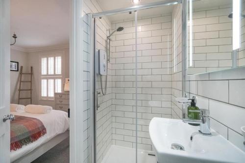 考斯的住宿－Crossjack Cottage，白色的浴室设有水槽和一张床