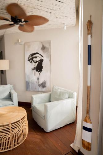 a living room with a white couch and a ceiling fan at La Posta Beach Hotel in Punta del Este