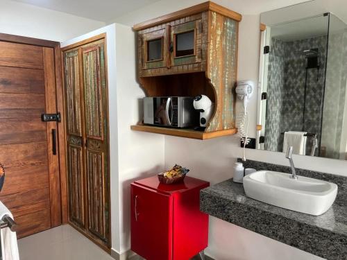 baño con lavabo y armario rojo en suites vista pro mar ilhabela, en Ilhabela