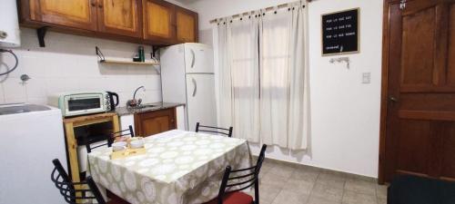 a kitchen with a table with chairs and a refrigerator at La Plaza in Formosa