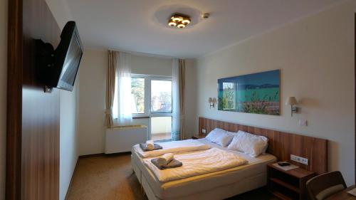 a bedroom with a bed with towels on it at Balaton Colors Beach Hotel in Siófok