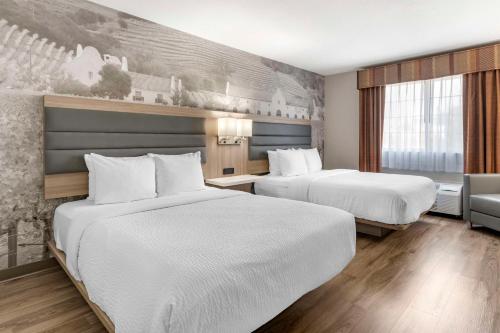 a hotel room with two beds and a couch at Best Western Plus Vineyard Inn in Livermore