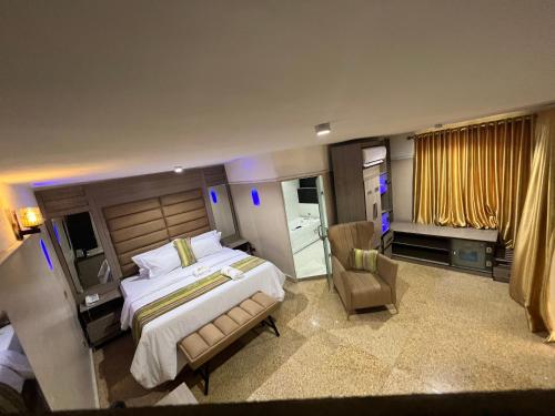 - une chambre avec un grand lit et une chaise dans l'établissement Ikeja Airport View, à Lagos
