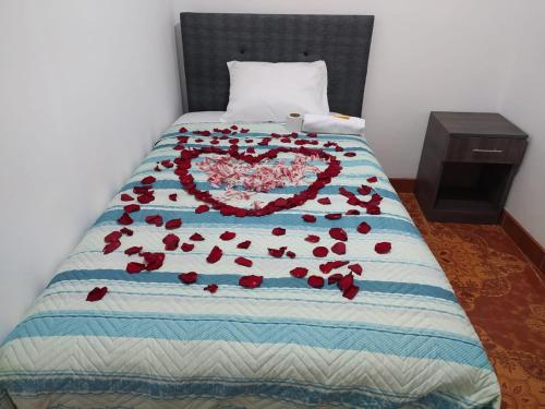Una cama con un corazón hecho de rosas en HOSPEDAJE EL ARCO, en Ayacucho
