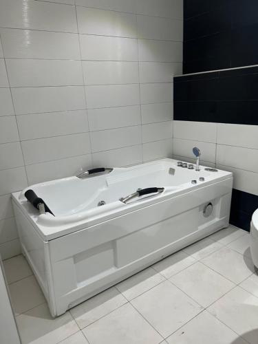 a white bath tub in a bathroom with a toilet at Ikeja Airport View in Lagos
