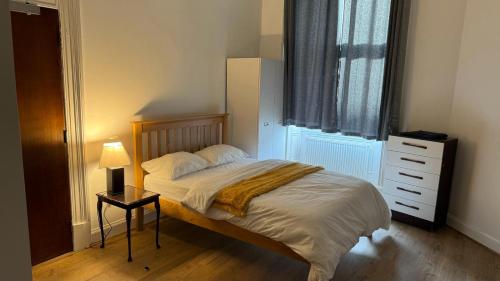 1 dormitorio con 1 cama, vestidor y ventana en Large 3 Bed Apt close to city, OVO Hydro and Ibrox Stadium en Glasgow