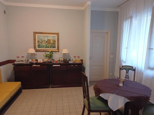a living room with a table and a couch at Albergo Etico Cesenatico in Cesenatico
