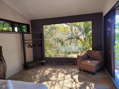 a room with a chair and a large window at Casa del Arte - Playa Maderas in El Plantel